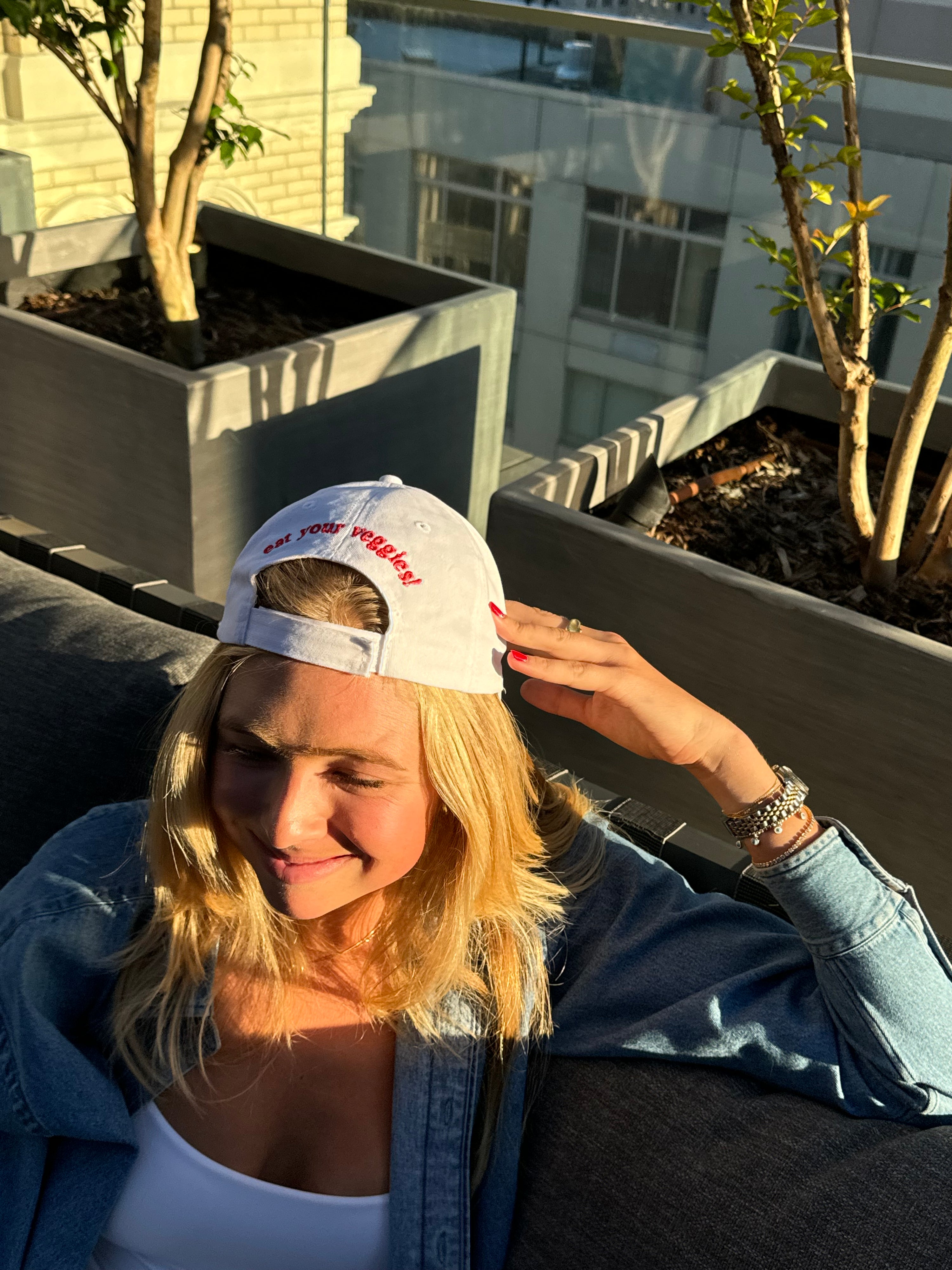 backwards shot of the edggies veggies cap, blonde girl smiling enjoying sunny summer afternoon